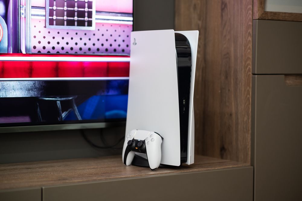 PlayStation 5 konzola i DualSense kontroler postavljeni pored televizora.